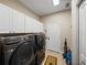 Convenient laundry room with washer, dryer, white cabinetry and tile floor at 6107 Ibispark Dr, Lithia, FL 33547
