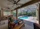 Covered patio with outdoor kitchen overlooks sparkling screened pool at 6107 Ibispark Dr, Lithia, FL 33547
