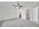 An open bedroom offers neutral carpet, ceiling fan, and bathroom views at 7459 Oxford Garden Cir, Apollo Beach, FL 33572