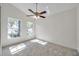 Light-filled bedroom featuring two windows, plush carpeting, and a ceiling fan at 7459 Oxford Garden Cir, Apollo Beach, FL 33572