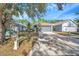 Lovely home with a well-manicured lawn, mature trees, and a long driveway leading to an attached two-car garage at 7459 Oxford Garden Cir, Apollo Beach, FL 33572