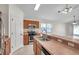 Open-concept kitchen featuring stainless steel appliances, wooden cabinetry, and a breakfast bar overlooking the adjacent living area at 7459 Oxford Garden Cir, Apollo Beach, FL 33572