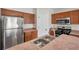 Well-equipped kitchen with stainless steel appliances, wood cabinets, and a functional layout, offering style and convenience at 7459 Oxford Garden Cir, Apollo Beach, FL 33572