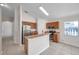 Modern kitchen boasting stainless steel appliances, breakfast bar, and wood cabinetry, flowing seamlessly into the living spaces at 7459 Oxford Garden Cir, Apollo Beach, FL 33572