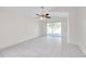 Spacious living room with tile flooring, ceiling fan, and sliding glass doors leading to the backyard at 7459 Oxford Garden Cir, Apollo Beach, FL 33572