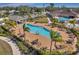 Community pool with ample lounge seating and a covered pavilion, surrounded by lush landscaping and palm trees at 7459 Oxford Garden Cir, Apollo Beach, FL 33572