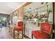 Home bar featuring decorative chairs, mirrored backsplash, and plenty of storage at 7623 Radcliffe Cir # 112A, Port Richey, FL 34668