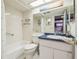 Bright bathroom features a white tub, toilet, vanity with a blue countertop, and a large mirror at 7623 Radcliffe Cir # 112A, Port Richey, FL 34668
