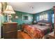 Cozy bedroom features dark green walls, wood flooring, and a bed with decorative pillows and a patterned comforter at 7623 Radcliffe Cir # 112A, Port Richey, FL 34668