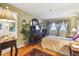 Well-lit bedroom featuring a large dresser, comfortable furnishings, and wood flooring at 7623 Radcliffe Cir # 112A, Port Richey, FL 34668