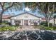 Community clubhouse featuring ample guest parking, an American flag, and well-maintained landscaping at 7623 Radcliffe Cir # 112A, Port Richey, FL 34668