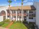 Two-story condo building with balconies, well-maintained landscaping, and easy access to the units via walkway at 7623 Radcliffe Cir # 112A, Port Richey, FL 34668
