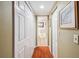 Hallway with closet space leading to a bathroom with a neutral color scheme at 7623 Radcliffe Cir # 112A, Port Richey, FL 34668