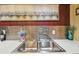 Close-up of the kitchenette's stainless steel sink and textured backsplash at 7623 Radcliffe Cir # 112A, Port Richey, FL 34668