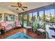 Relaxing sunroom with a ceiling fan, tiled floors, and views of the lush backyard at 7623 Radcliffe Cir # 112A, Port Richey, FL 34668
