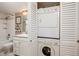 Bathroom featuring laundry machines with a bathtub and white cabinets at 7700 Sun Island S Dr # 608, South Pasadena, FL 33707