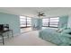 Lovely bedroom with two walls of windows providing lots of light, neutral carpet, and light blue walls at 7700 Sun Island S Dr # 608, South Pasadena, FL 33707