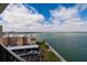 Daytime view of condo exterior and covered parking with waterfront and palms on landscaped grounds at 7700 Sun Island S Dr # 608, South Pasadena, FL 33707