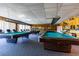 Well-lit game room with multiple pool tables and seating areas at 7700 Sun Island S Dr # 608, South Pasadena, FL 33707