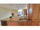 Well-lit kitchen features granite counters, wooden cabinets, and wine refrigerator at 7700 Sun Island S Dr # 608, South Pasadena, FL 33707