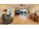 Inviting living room features wood floors, a ceiling fan, and sliding glass doors to the balcony at 7700 Sun Island S Dr # 608, South Pasadena, FL 33707