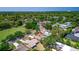 Aerial view showing nearby tennis courts, a sports field, and the home's position in a vibrant community at 834 Riverside Dr, Tarpon Springs, FL 34689
