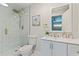 This elegant bathroom features a glass-enclosed shower, white vanity, and gold fixtures at 834 Riverside Dr, Tarpon Springs, FL 34689