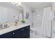 This renovated bathroom includes a blue vanity, shower-tub combo and decorative gold fixtures at 834 Riverside Dr, Tarpon Springs, FL 34689