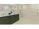This bathroom features a sleek, green vanity with gold hardware and a spacious, frameless glass shower at 834 Riverside Dr, Tarpon Springs, FL 34689