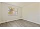 This bedroom offers neutral walls, wood floors, and a sunlit window with privacy blinds at 834 Riverside Dr, Tarpon Springs, FL 34689