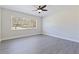 This bright bedroom has grey vinyl floors, neutral walls, a modern ceiling fan, and a window at 834 Riverside Dr, Tarpon Springs, FL 34689