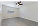 This bedroom is completed with grey vinyl floors, neutral walls and a modern ceiling fan with light at 834 Riverside Dr, Tarpon Springs, FL 34689
