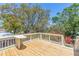Enjoy the view from this wooden deck overlooking trees and flowers with a small table at 834 Riverside Dr, Tarpon Springs, FL 34689