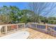 A wooden deck with white railings, perfect for enjoying views of surrounding trees and foliage at 834 Riverside Dr, Tarpon Springs, FL 34689