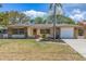 Charming single-story home boasting a stone facade, manicured lawn, and a convenient attached garage at 834 Riverside Dr, Tarpon Springs, FL 34689