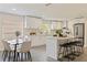 Modern kitchen boasting white cabinets, a sleek island with seating, and stainless steel appliances at 834 Riverside Dr, Tarpon Springs, FL 34689