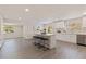 Open-concept kitchen features white cabinets, stainless steel appliances, island with seating, and view to an adjacent living space at 834 Riverside Dr, Tarpon Springs, FL 34689