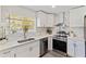 Bright kitchen showcases stainless steel appliances, white cabinetry, marble countertops, and a view from the window at 834 Riverside Dr, Tarpon Springs, FL 34689