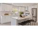 Modern kitchen showcasing white cabinets, an island with barstools, and stainless steel appliances at 834 Riverside Dr, Tarpon Springs, FL 34689