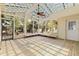 Bright sunroom featuring a glass ceiling, ceiling fan, wood flooring, and large windows showcasing the outdoor scenery at 834 Riverside Dr, Tarpon Springs, FL 34689