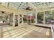 This screened-in sunroom features a wood floor, lattice ceiling, and views of the backyard at 834 Riverside Dr, Tarpon Springs, FL 34689