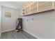 Utility room with water heater, overhead storage, and window for natural light at 834 Riverside Dr, Tarpon Springs, FL 34689