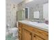 Bathroom with light patterned wallpaper, wood vanity, and a large, bright mirror at 8681 Bardmoor Blvd # 208C, Seminole, FL 33777