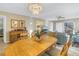 Bright dining area with chandelier, wood table, and view of the living room with plenty of natural light at 8681 Bardmoor Blvd # 208C, Seminole, FL 33777