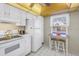 Well-lit kitchen with a compact dining area, complemented by white appliances at 8681 Bardmoor Blvd # 208C, Seminole, FL 33777