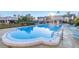 Community pool with chairs and condos in the distance, set in a lush, tropical landscape at 8681 Bardmoor Blvd # 208C, Seminole, FL 33777