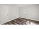 This is a bedroom with wood-look flooring, window, and a white door at 924 N Castle Ct, Tampa, FL 33612