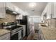 Modern kitchen featuring stainless steel appliances, granite countertops, white cabinets and decorative backsplash at 924 N Castle Ct, Tampa, FL 33612