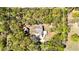 An aerial view of the home in a wooded and landscaped setting at 9377 Preston Rd, Brooksville, FL 34601