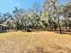 Large backyard surrounded by tall trees on a sunny day at 9377 Preston Rd, Brooksville, FL 34601